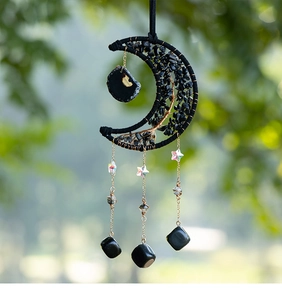 Detail of crescent moon suncatcher with black tree of life design and hanging crystal stars