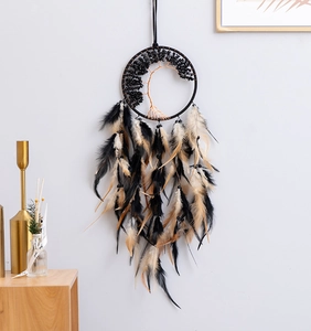 Detail of tree of life dreamcatcher with black stones and natural feathers on wall