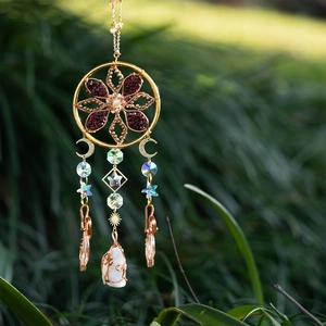 Bohemian gold suncatcher with crystal beads and white raw stone hanging in nature