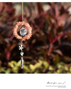 Detail of crystal suncatcher with crushed watermelon stones and faceted glass prisms