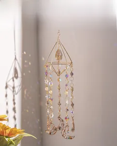 Detail of geometric suncatcher with golden wire, colorful crystals and moon pendant