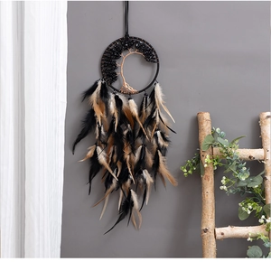 Detail view of Tree of Life dreamcatcher with black stones and natural feathers hanging