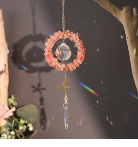 Watermelon crystal suncatcher casting rainbow light spots on wall via outdoor sunlight