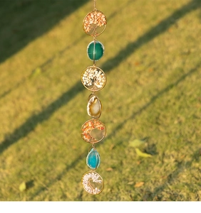 Detailed view of Tree of Life crystal ornaments with colorful agate slices and metal wire