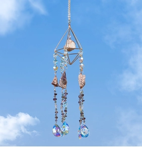 Detail of amethyst prism suncatcher with golden geometric frame against a blue sky
