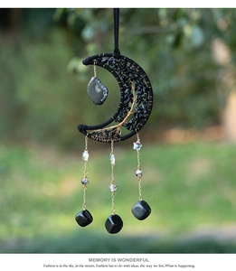 Detail of moon-shaped tree of life suncatcher with black stones and copper wire weaving