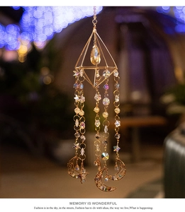 Detail of crystal suncatcher with golden geometric frame and moon star pendants