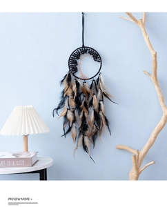 Close-up of bohemian dream catcher featuring a woven life tree and black feathers