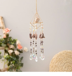 Detail of amethyst suncatcher with golden geometric frame and hanging crystals