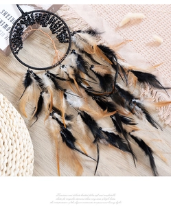 Detail of tree of life dreamcatcher with black stones and feathers on boho home background