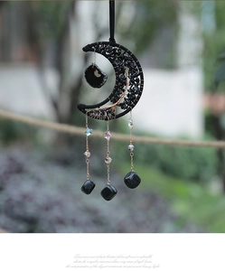 Detail of crescent moon suncatcher with black natural stones and crystal star pendant