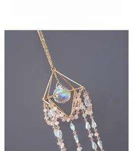 Detailed macro view of geometric suncatcher with crystal ball and beaded tassels
