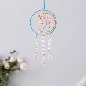 Macro shot of tree of life suncatcher with pink crystals and clear faceted glass prisms
