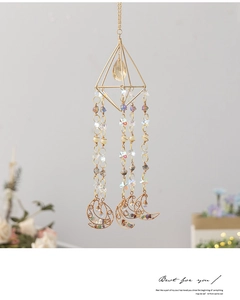 Detailed shot of handmade gold crystal suncatcher with colorful natural stones and moon pendant