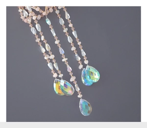 Detailed close-up of crystal suncatcher with pink beads and aurora pear-shaped prisms