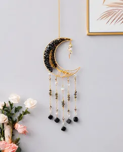 Detailed close-up of a moon-shaped dream catcher with black crushed stones and crystal beads