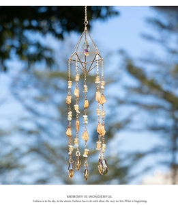 Detail of golden geometric sun catcher with amber raw stones and crystal prism pendant
