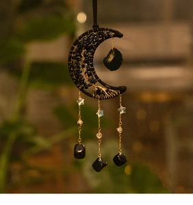 Detail of black crescent moon suncatcher with crystal stars and hanging gemstones