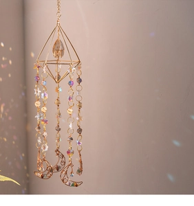 Detail of bohemian gold geometric crystal suncatcher with moon and colorful stones