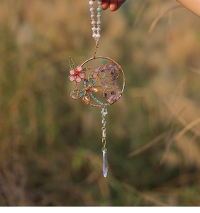 Detail eines handgefertigten Kristall-Libellen-Anhängers mit rosa Steinblume