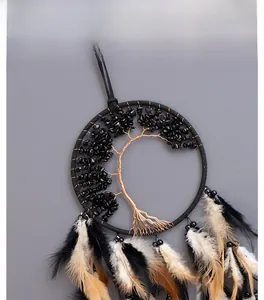 Macro view of dreamcatcher featuring wire-woven tree of life with black stones and feathers