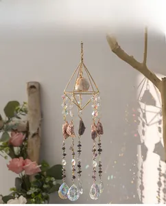 Close-up of geometric amethyst suncatcher casting rainbow light on white wall