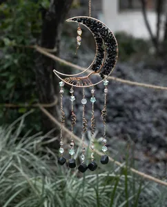 Detail of moon-shaped tree of life dream catcher with black stones and golden tassels