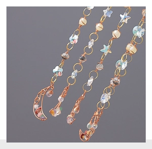Macro view of handcrafted gold wire wrapped moon and star charms with colorful gemstones