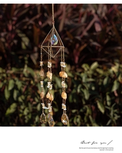 Close-up of geometric golden suncatcher featuring raw citrine stones and crystal prisms