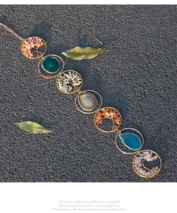 Detail of life tree chakra stones and polished agate slices on a hanging ornament