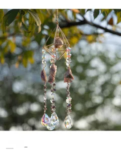 Close-up of bohemian amethyst suncatcher with gold metal frame hanging in a garden