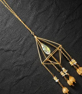Detailed view of geometric golden suncatcher with citrine stones and crystal prism