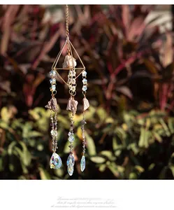 Macro detail of amethyst suncatcher with golden geometric frame and hanging crystals