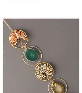 Close-up of wire-wrapped tree of life pendants and agate slices on a gold ring hanger