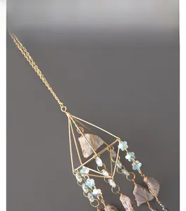 Detailed close-up of golden geometric wire frame with raw amethyst crystal stone