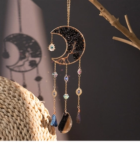 Detailed shot of celestial moon suncatcher with tree of life design and blue tassels