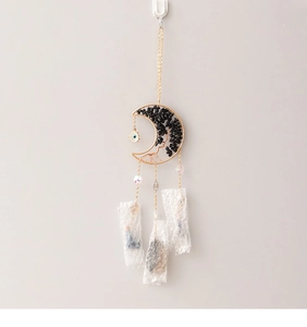 Detailed view of moon suncatcher with black stones and evil eye crystal pendant