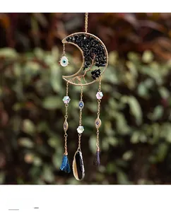 Close-up of golden moon suncatcher with tree of life, black stones and evil eye beads