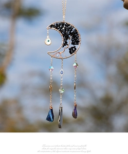 Macro detail of moon suncatcher featuring evil eye beads and tree of life crystals