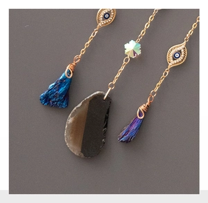 Detail of evil eye suncatchers with iridescent crystals and raw stone pendants