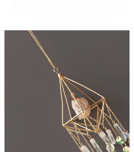 Detail of geometric metal frame with natural white crystal stone and hanging prism beads