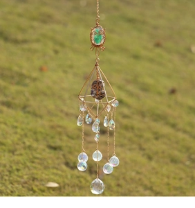 Macro view of handmade owl wire-wrapped gemstone with crystal prisms suncatcher