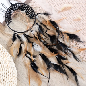 Bohemian Tree of Life dream catcher with black and white feathers on a wooden background