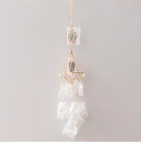 Detail of golden geometric owl suncatcher featuring diamond-shaped metal frame