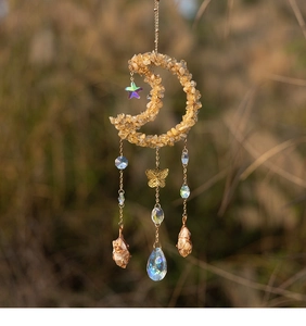 Detail of moon suncatcher with yellow citrine crystals and metal butterfly charms