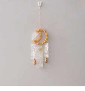 Detail of moon-shaped suncatcher with yellow crystals and iridescent moon charms