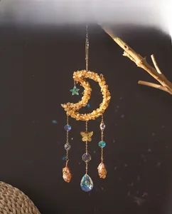 Detail view of crescent suncatcher with yellow stones and sparkling crystal prism pendants