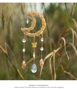 Detail of bohemian suncatcher with yellow citrine moon and golden butterfly hanging accents