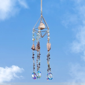 Amethyst suncatcher with geometric gold frame and raw crystal stones against a blue sky