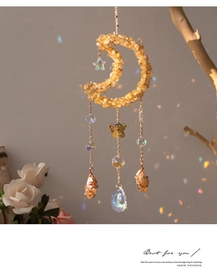 Detail of moon suncatcher with yellow crystals, metal butterfly and rainbow light effects